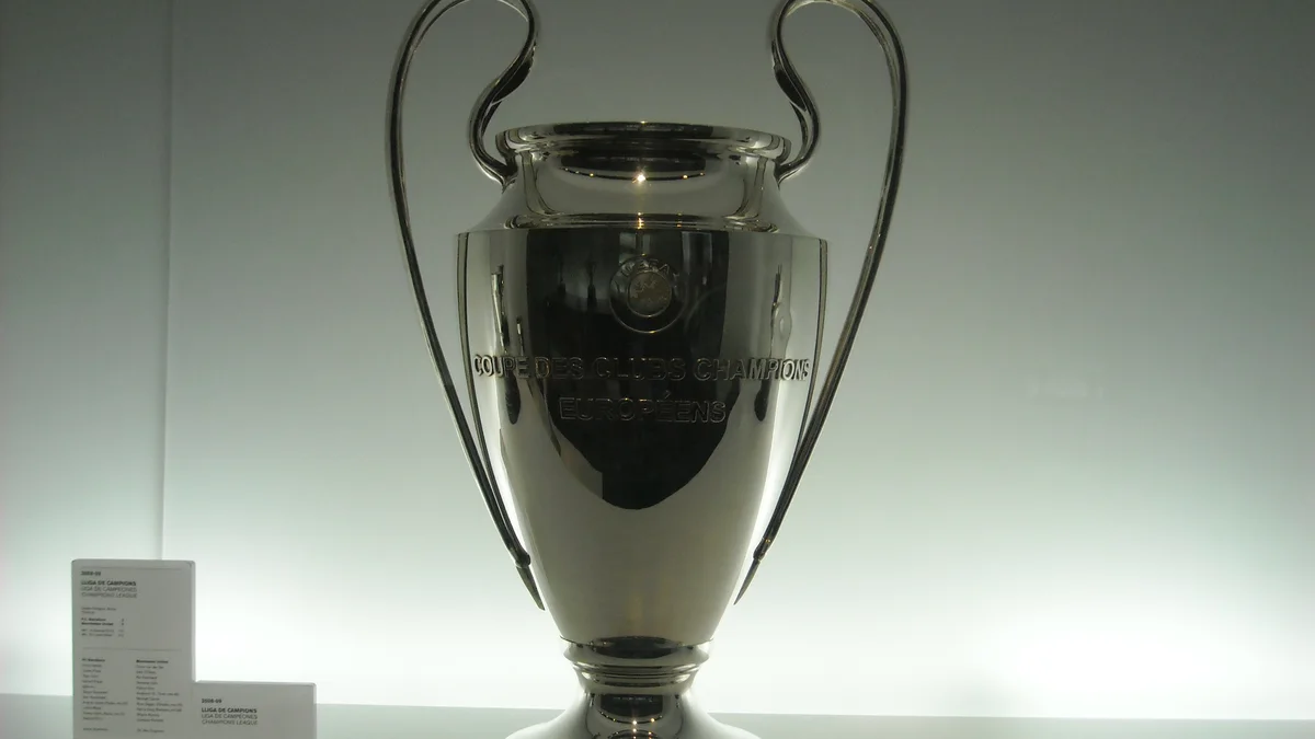 The UEFA Champions League trophy, decorated with red ribbons, photographed in close-up