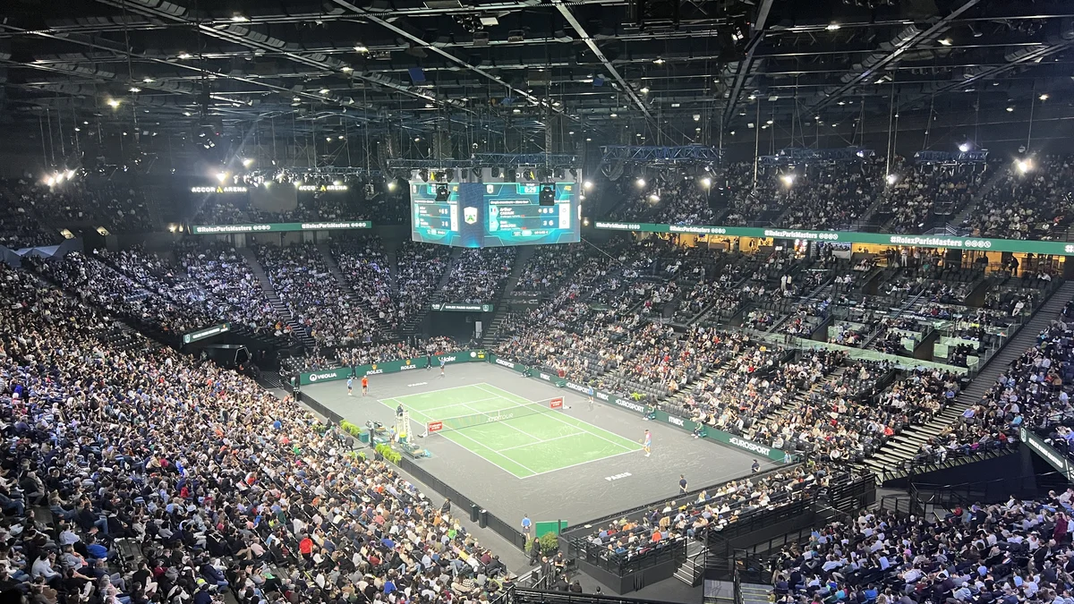 High-angle view of a packed Accor Arena in Paris-Bercy, tiered seating and lighting, during an indoor sporting event